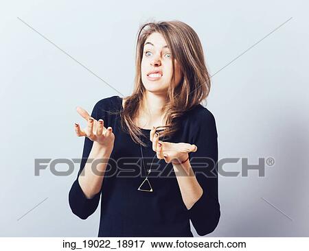 Stock Photo - girl holding something in his hand. Isolated on gray background. Fotosearch