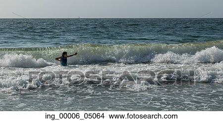 Girl playing in ocean waves, Vina Del Mar, Chile View Large Photo Image Picture - Girl playing in ocean waves, Vina Del Mar, Chile. Fotosearch