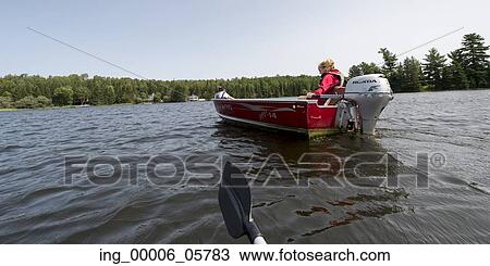 Girl sitting on motorboat in a lake, Lake of the Woods, Ontario, Canada View Large Photo Image Stock Image - Girl sitting on motorboat in a lake, Lake of the Woods, Ontario, Canada. Fotosearch