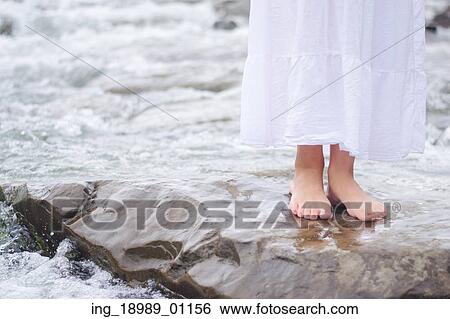 Stock Photograph - Girl soaking feet in brook. Fotosearch