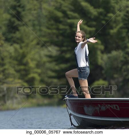 Girl standing on boat with her arms outstretched, Lake of the Woods, Ontario, Canada View Large Photo Image Stock Photo - Girl standing on boat with her arms outstretched, Lake of the Woods, Ontario, Canada. Fotosearch