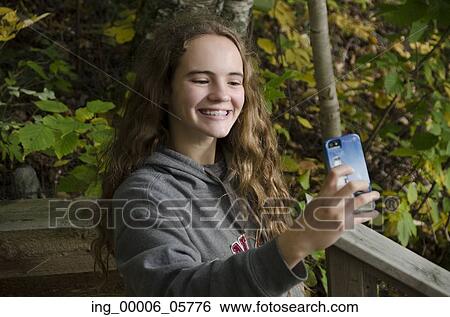 Girl taking selfie with a smartphone, Lake of the Woods, Ontario, Canada View Large Photo Image Stock Photograph - Girl taking selfie with a smartphone, Lake of the Woods, Ontario, Canada. Fotosearch