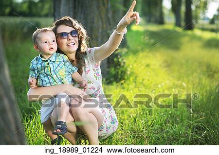Glad mum indicating her son something interesting View Large Photo Image Picture - Glad mum indicating her son something interesting. Fotosearch