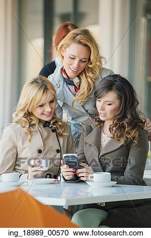 Stock Image - Group of the smiling ladies in the coffee shop. Fotosearch
