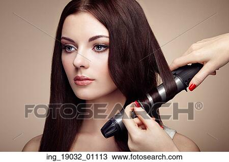 Hairdresser woman curls her hair. Portrait of young beautiful girl with luxurious hair. Fashion and beauty. Perfect make-up View Large Photo Image Stock Image - Hairdresser woman curls her hair. Portrait of young beautiful girl with luxurious hair. Fashion and beauty. Perfect make-up. Fotosearch