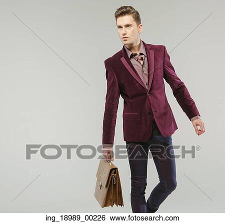 Stock Photograph - Handsome guy carrying the leather handbag. Fotosearch