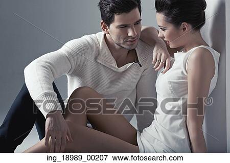 Stock Photo - Handsome man touching soft skin of brunette woman. Fotosearch