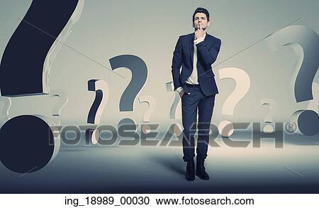 Stock Image - Handsome young businessman about questions. Fotosearch