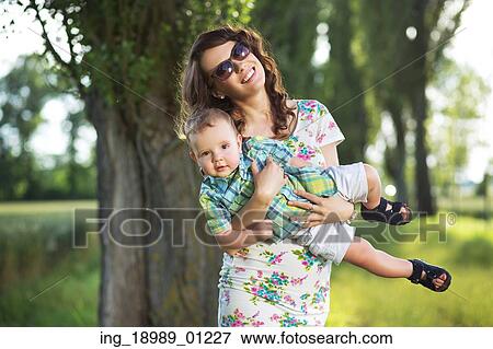 Happy mom holding her cute child View Large Photo Image Stock Photo - Happy mom holding her cute child. Fotosearch