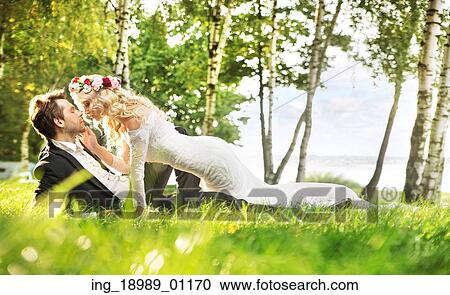 Just married couple relaxing on the green meadow View Large Photo Image Stock Image - Just married couple relaxing on the green meadow. Fotosearch