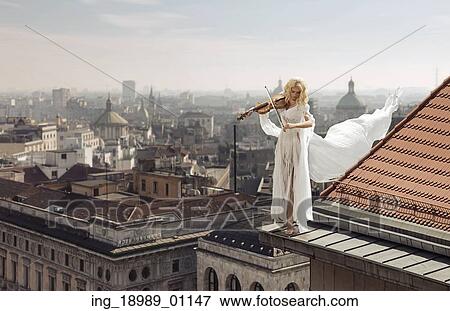 Lady playing the violin on the top of the edge of the roof View Large Photo Image Stock Photo - Lady playing the violin on the top of the edge of the roof. Fotosearch