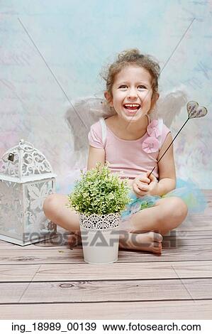 Stock Photo - Laughing cute witch with fancy wand. Fotosearch