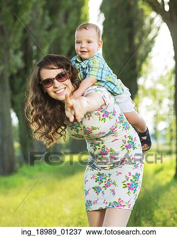 Stock Photo - Laughing mom playing with her baby son. Fotosearch