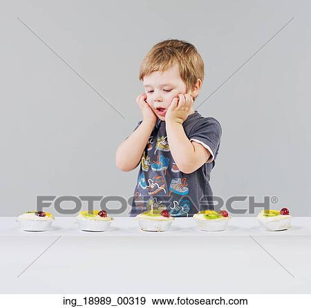 Stock Photo - Little boy and a lot of delicious sweets. Fotosearch