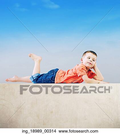 Picture - Little boy relaxing after tiring play. Fotosearch