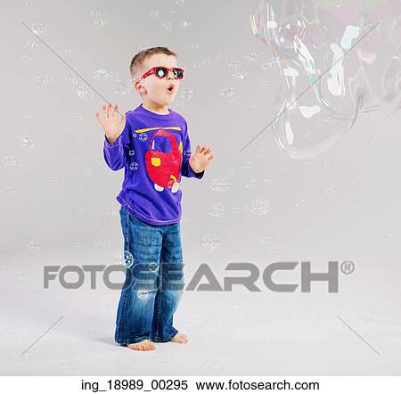 Stock Photography - Little child playing with soap bubbles. Fotosearch