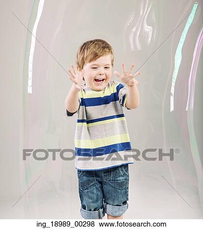 Stock Photo - Little cute boy playing a soap bubbles. Fotosearch