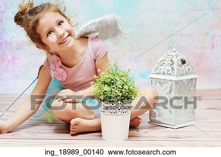 Stock Image - Little cute witch with charming smile. Fotosearch