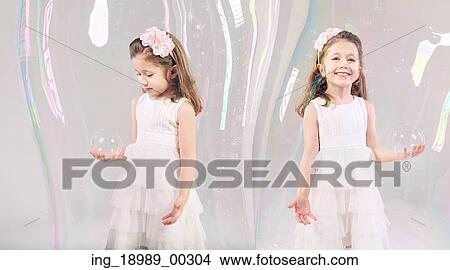 Little girls closed in large soap bubbles View Large Photo Image Picture - Little girls closed in large soap bubbles. Fotosearch