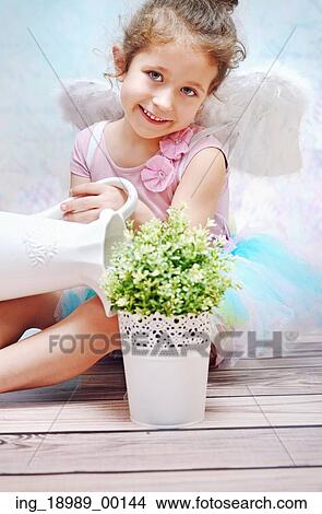 Little smiling kid watering plant View Large Photo Image Picture - Little smiling kid watering plant. Fotosearch