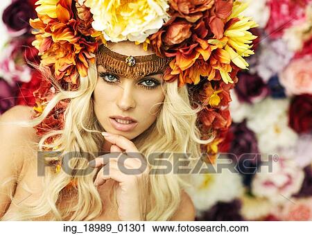 Stock Image - Marvelous blonde woman with the flower hat. Fotosearch