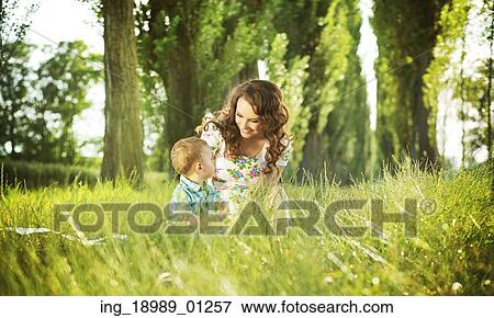 Stock Photo - Mom sitting on the blanket with little son. Fotosearch
