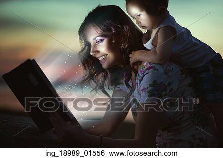 Stock Photograph - Mommy reading amazing book for her baby. Fotosearch