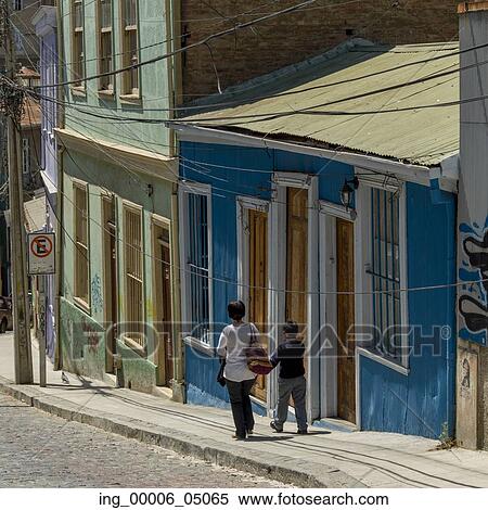 Stock Photography - Mother and son walking on street along houses, Valparaiso, Chile. Fotosearch