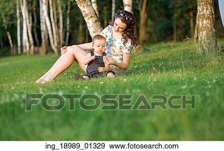 Stock Photo - Mother looking after her little baby. Fotosearch