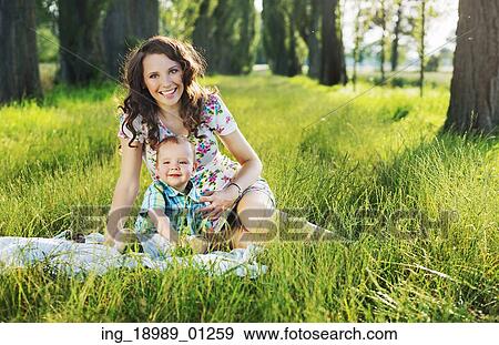 Mother with child sitting on the blue blanket View Large Photo Image Stock Photo - Mother with child sitting on the blue blanket. Fotosearch