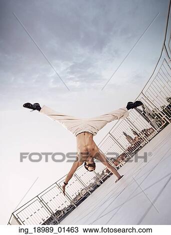 Stock Image - Muscular guy doing very hard exercises. Fotosearch