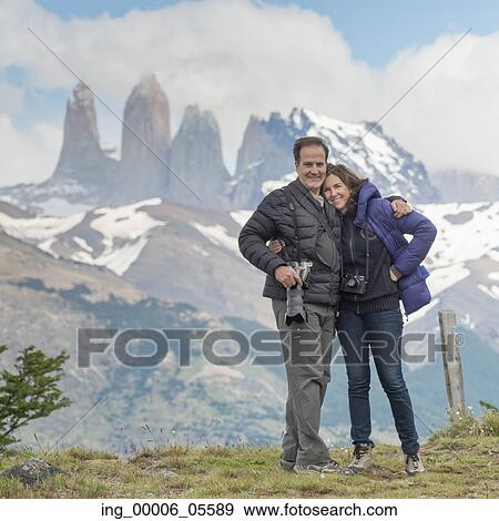 Stock Photo - Portrait of a couple with mountain range in the background, Torres Del Paine National Park, Patagonia, Chile. Fotosearch