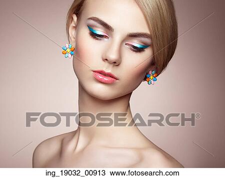 Stock Image - Portrait of beautiful sensual woman with elegant hairstyle. Perfect makeup. Blonde girl. Fashion photo. Jewelry. Fotosearch