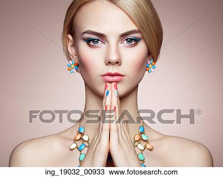 Stock Image - Portrait of beautiful sensual woman with elegant hairstyle. Perfect makeup. Blonde girl. Fashion photo. Jewelry. Fotosearch