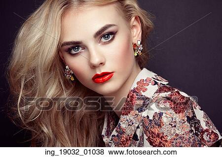 Stock Photo - Portrait of beautiful sensual woman with elegant hairstyle. Perfect makeup. Blonde girl. Fashion photo. Jewelry and dress. Fotosearch