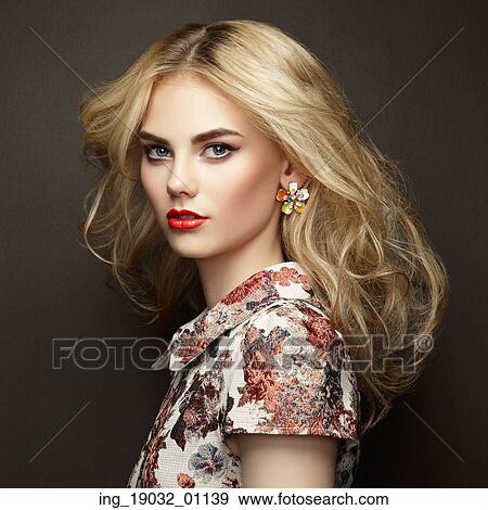 Stock Photo - Portrait of beautiful sensual woman with elegant hairstyle. Perfect makeup. Blonde girl. Fashion photo. Jewelry and dress. Fotosearch