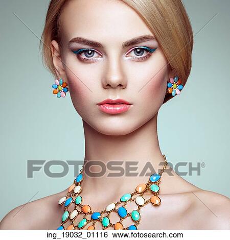 Stock Photograph - Portrait of beautiful sensual woman with elegant hairstyle. Perfect makeup. Blonde girl. Fashion photo. Jewelry. Fotosearch