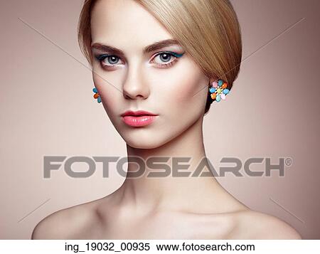 Stock Photography - Portrait of beautiful sensual woman with elegant hairstyle. Perfect makeup. Blonde girl. Fashion photo. Jewelry. Fotosearch