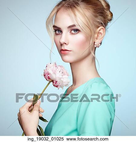 Stock Photography - Portrait of beautiful sensual woman with elegant hairstyle. Perfect makeup. Blonde girl. Fashion photo. Flowers. Fotosearch