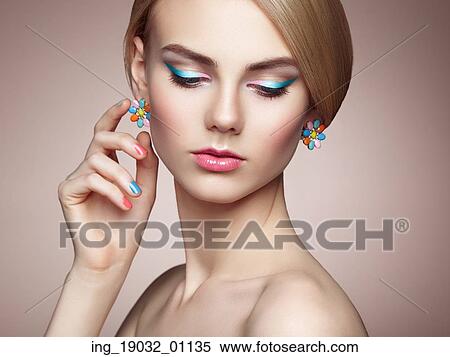 Stock Photography - Portrait of beautiful sensual woman with elegant hairstyle. Perfect makeup. Blonde girl. Fashion photo. Jewelry. Fotosearch