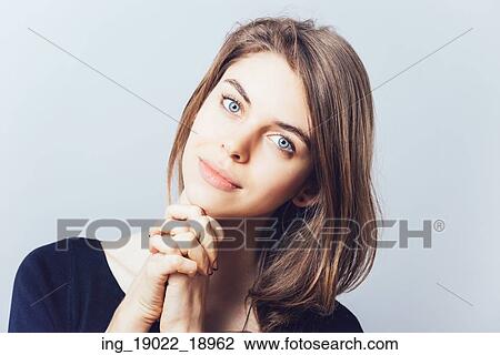 portrait of beautiful young brunette girl holding hand on chin isolated on gray background View Large Photo Image Stock Image - portrait of beautiful young brunette girl holding hand on chin isolated on gray background. Fotosearch