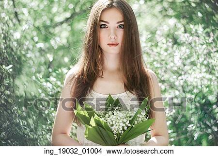 Picture - Portrait of beautiful young woman with lily of the valley. Girl on nature. Spring flowers. Fashion beauty. Fotosearch