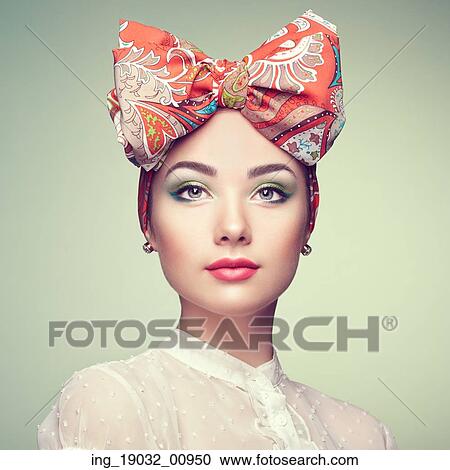 Stock Image - Portrait of beautiful young woman with bow. Brunette girl. Beauty fashion. Cosmetic make-up. Fotosearch