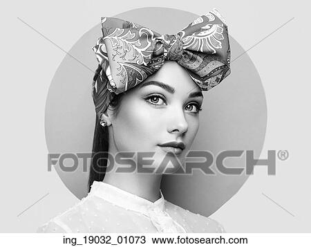 Stock Image - Portrait of beautiful young woman with bow. Brunette girl. Beauty fashion. Cosmetic make-up. Black and white. Fotosearch