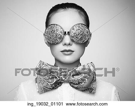 Stock Image - Portrait of beautiful young woman with colored glasses. Beauty fashion. Perfect make-up. Colorful decoration. Jewelry. Black and white. Fotosearch