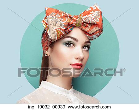 Stock Photo - Portrait of beautiful young woman with bow. Brunette girl. Beauty fashion. Cosmetic make-up. Fotosearch