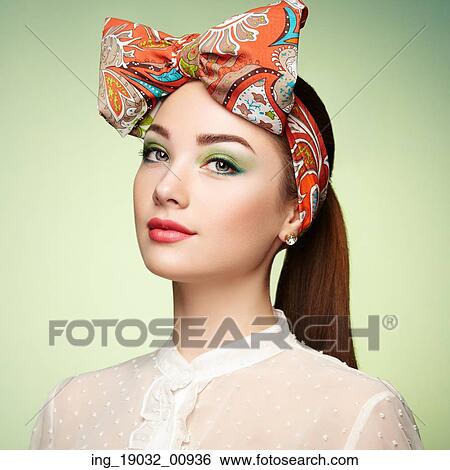 Stock Photograph - Portrait of beautiful young woman with bow. Brunette girl. Beauty fashion. Cosmetic make-up. Fotosearch