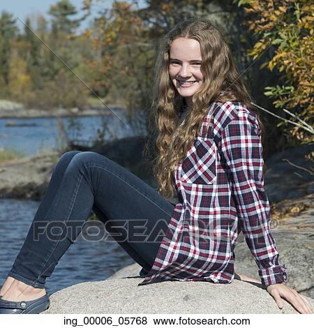 Portrait of happy girl sitting on rock at lakeside, Lake of the Woods, Ontario, Canada View Large Photo Image Stock Photo - Portrait of happy girl sitting on rock at lakeside, Lake of the Woods, Ontario, Canada. Fotosearch
