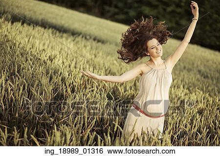 Stock Photograph - Portrait of the joyful pregnant lady among the cereal crop. Fotosearch