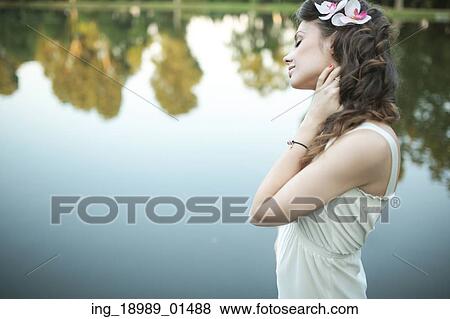 Stock Photo - Portrait of the lady relaxing by the lakeside. Fotosearch
